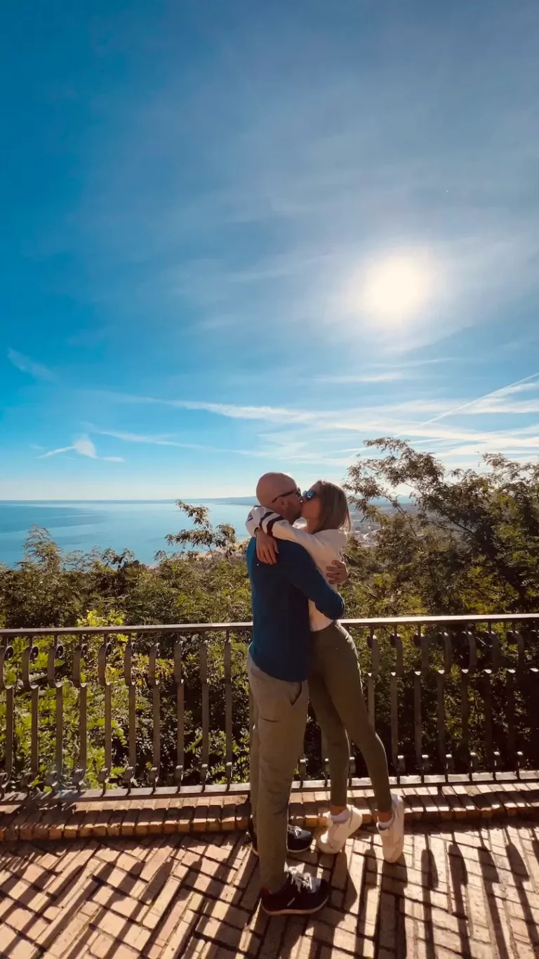 Coppia in primo piano con il belvedere di Vasto e il mare in lontananza, durante una visita al parco di Vasto.